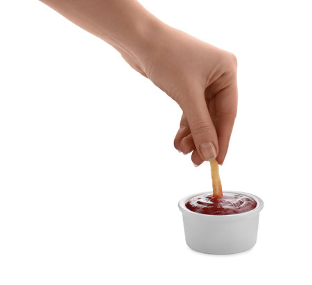 Woman dipping french fry into ketchup on white background, closeupの写真素材