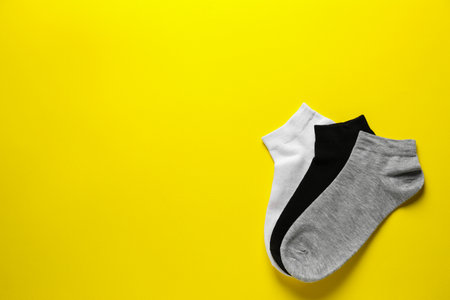 Different socks on yellow background, flat lay. Space for textの写真素材