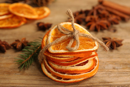 Dry orange slices and fir branch on wooden table, closeupの写真素材