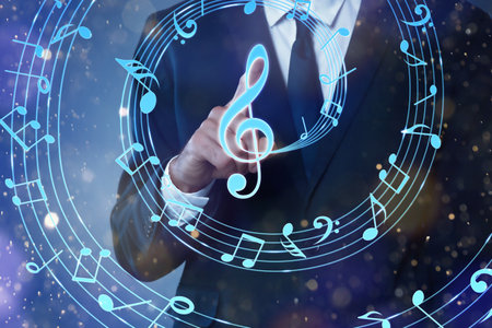 Musician pointing at staff with music notes and symbols on color background, closeupの写真素材