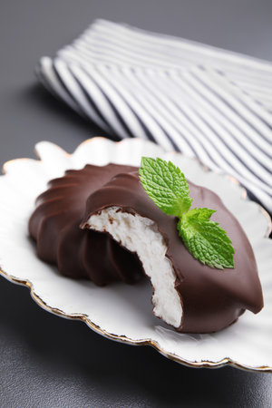 Delicious chocolate covered zephyrs with mint on black table, closeupの写真素材