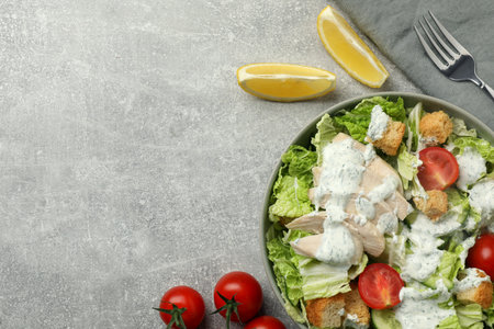 Delicious salad with Chinese cabbage, cucumber, meat and tomatoes served on gray table, flat lay. Space for textの写真素材