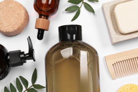 Flat lay composition with solid shampoo bar and bottles of cosmetic product on white backgroundの写真素材