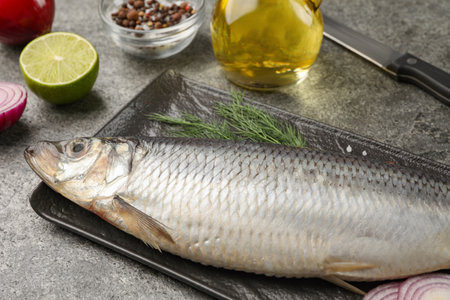 Delicious salted herring and ingredients on gray table, closeupの写真素材