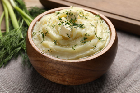 Bowl of delicious mashed potato with dill and butter on gray tablecloth, closeupの写真素材