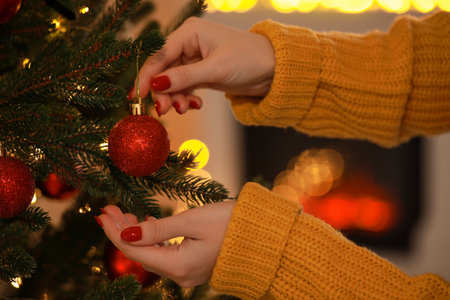 Woman decorating Christmas tree at home, closeupの写真素材