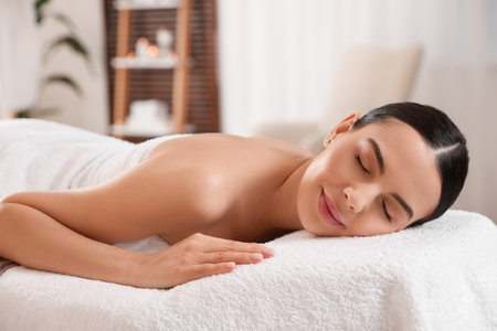 Young woman resting on massage couch in spa salonの写真素材