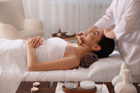 Young woman enjoying professional massage in spa salonの写真素材