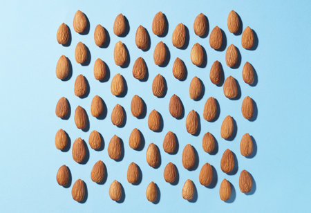 Delicious raw almonds on light blue background, flat layの写真素材