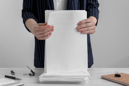 Woman stacking documents at white wooden table in office, closeupの写真素材