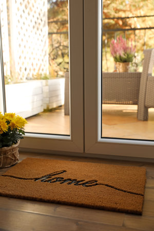 Doormat with word Home on parquet floor indoorsの写真素材