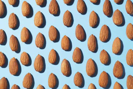 Delicious raw almonds on light blue background, flat layの写真素材