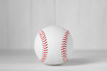 Baseball ball on white table, closeup. Sports equipment