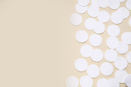 Many clean cotton pads on yellow background, flat lay. Space for textの写真素材