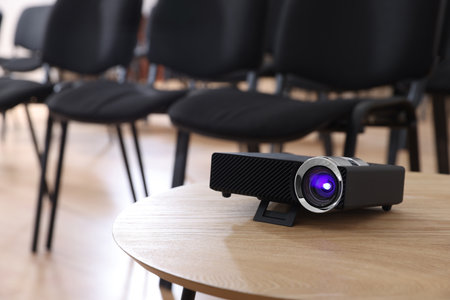 Modern video projector on table in conference roomの写真素材