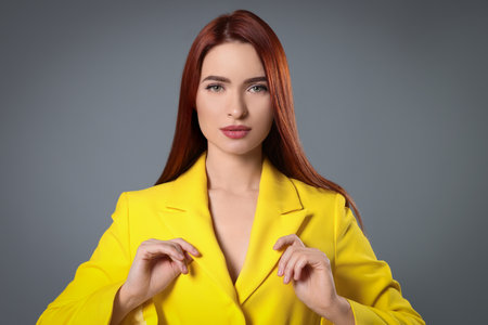 Beautiful woman with red dyed hair on light gray backgroundの写真素材
