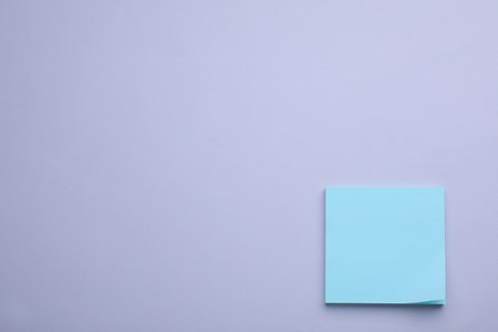Paper note on light purple background, flat lay. Space for textの写真素材