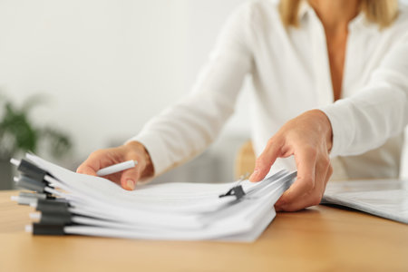 Woman working with documents at wooden table in office, closeupの写真素材
