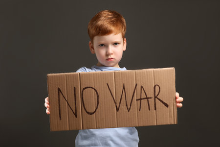 Boy holding poster No War against gray backgroundの写真素材