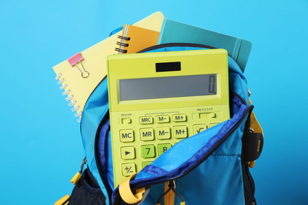 Backpack with different school stationery on light blue background, closeupの写真素材