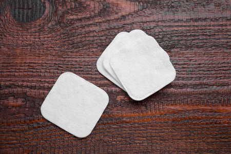 Clean cotton pads on wooden table, flat layの写真素材
