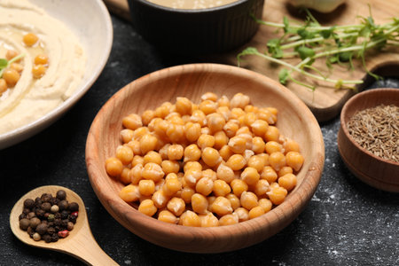 Delicious chickpeas and different products on black textured table, closeup. Hummus ingredientの写真素材