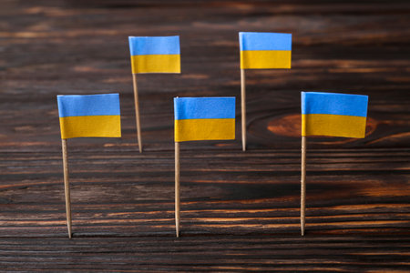 Small paper flags of Ukraine on wooden tableの写真素材