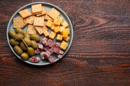 Toothpick appetizers. Pieces of cheese, sausage and olives on wooden table, top view with space for textの写真素材