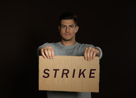 Man with Strike sign on dark backgroundの写真素材