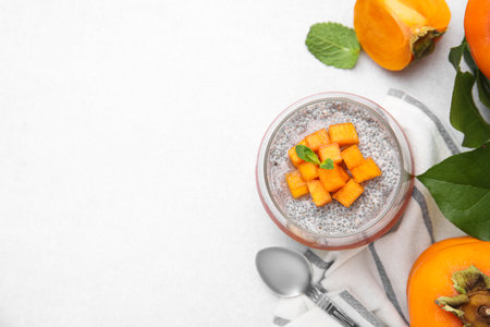 Delicious dessert with persimmon and chia seeds on table, flat lay. Space for textの写真素材