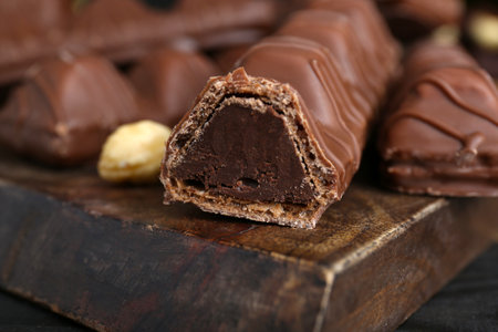 Sweet tasty chocolate bars on wooden board, closeupの写真素材