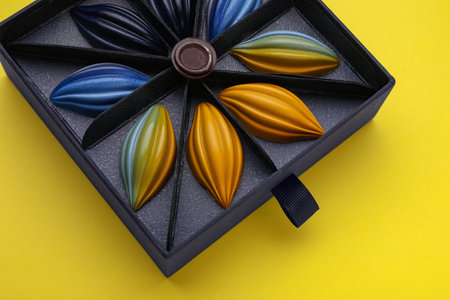 Box of tasty chocolate candies on yellow background, above viewの写真素材