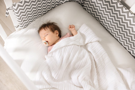Cute little baby sleeping on cozy bedの写真素材
