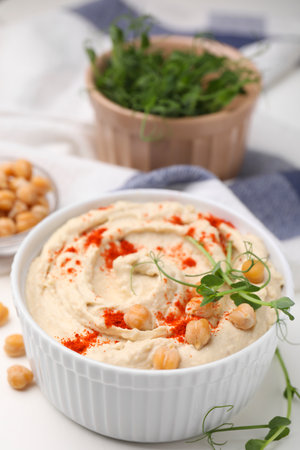 Delicious hummus with chickpeas and paprika served on white table, closeupの写真素材