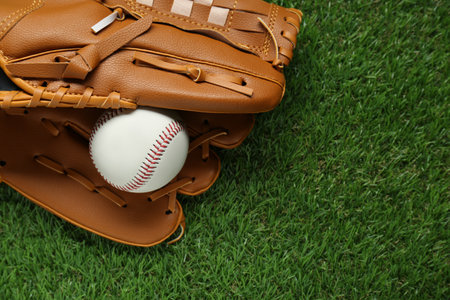Catcher's mitt and baseball ball on green grass, top view with space for text. sports gameの写真素材