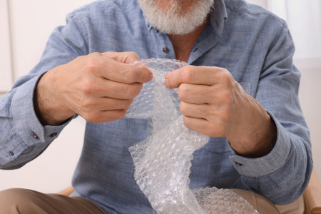 Senior man popping wrap at home, closeup. stress reliefの写真素材