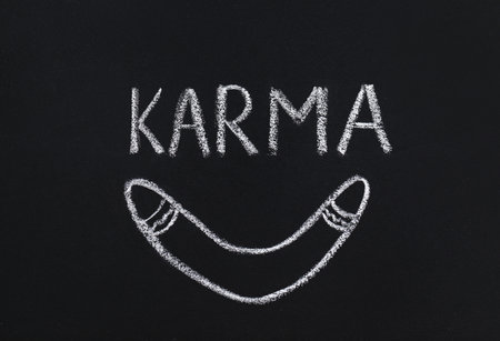 Drawn boomerang and word Karma written on blackboardの写真素材