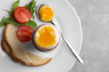 Breakfast with soft boiled egg on gray table, top view. Space for textの写真素材