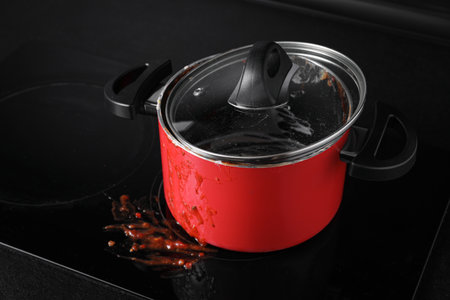 Dirty pot with lid on cooktop in kitchen