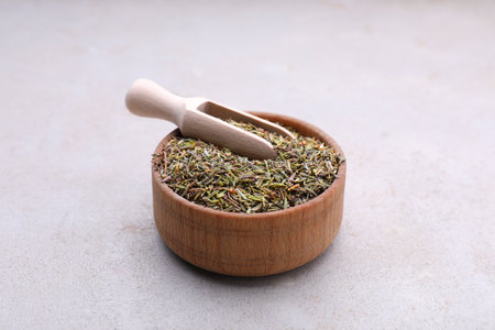 Bowl and scoop with dried thyme on gray table, closeupの写真素材
