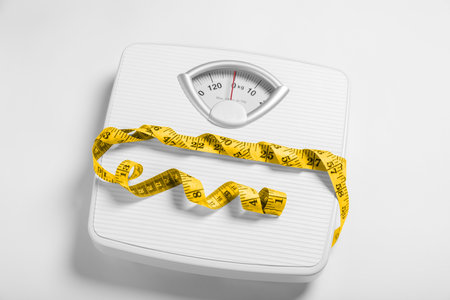 weight loss concept. Scales and measuring tape on white background
