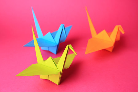 origami art. Colorful handmade paper cranes on pink backgroundの写真素材