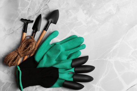 Gardening gloves, tools and thread on light gray marble table, flat lay. Space for textの写真素材