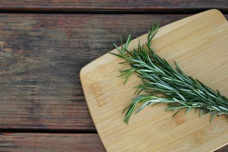 Bunch of fresh rosemary on wooden table, top view with space for text. aromatic herbsの写真素材