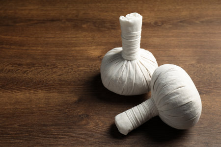 Herbal massage bags on wooden table, space for text. spa treatmentの写真素材