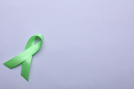 World Mental Health Day. Green ribbon on color background, top view with space for textの写真素材