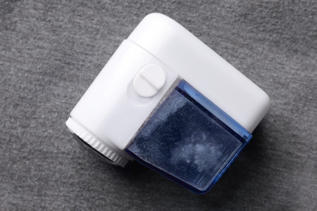Fabric shaver with fuzz on gray cloth, top viewの写真素材