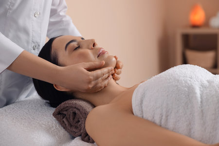 Young woman enjoying professional massage in spa salonの写真素材