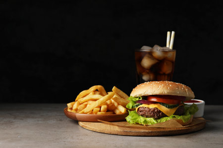 Delicious burger, soda drink and french fries served on gray table. Space for textの写真素材