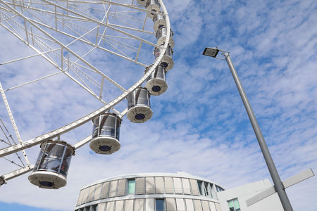 Beautiful Ferris wheel against cloudy sky, low angle viewの写真素材